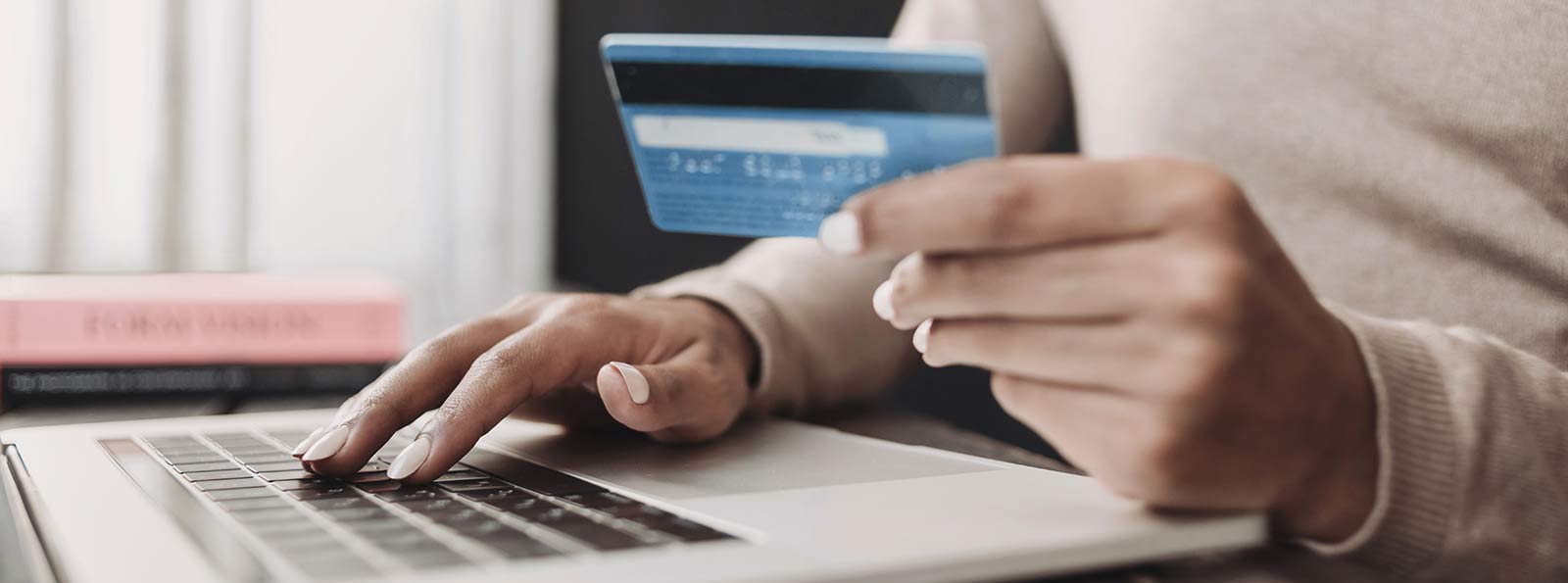 A lady using their credit or debit card on a laptop computer