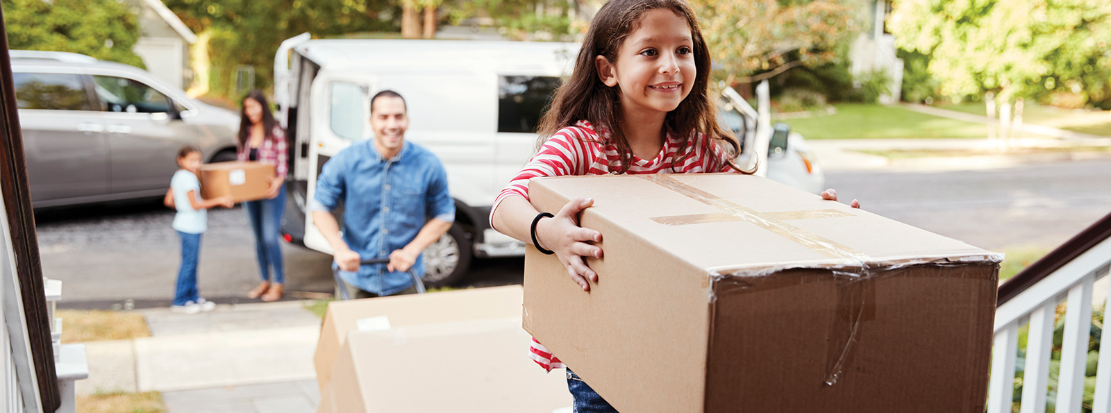 Girl walking into her new home with a moving box